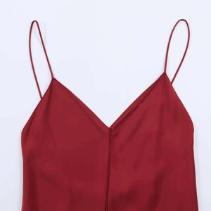 Close-up of elegant deep red satin dress with thin straps and a minimalist V-neck design