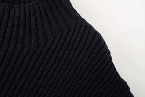 Detail view of the ribbed knit neckline and shoulder seams of a navy blue vest