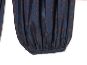 Detail of blue and brown checkered joggers with elastic cuffs and smooth fabric