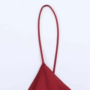 Detailed close-up of red satin midi dress thin straps and delicate stitching finish