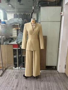 Detail von hellbeige tailliertem Blazer und weitem Hosenanzug für das Berufsleben