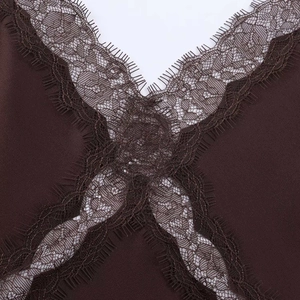 Detailed macro view of delicate eyelash lace trim on a dark coffee satin midi dress V-neckline