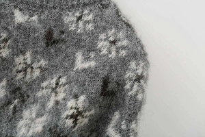 Close-up of jacquard knit fabric with fluffy texture and gray floral patterns