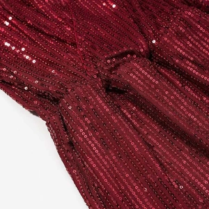 Detailed close-up of dark red sequin fabric texture with elegant vertical stripe pattern