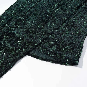 Detail of dark green sequins on mini dress showing metallic texture and quality lining