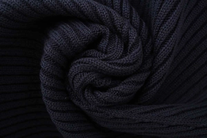 Close-up macro detail of thick navy blue ribbed knit texture and soft fabric folds