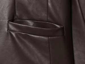 Close-up of vintage dark brown PU leather jacket showing pocket detail and grain texture