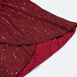 Detailed close-up of wine red sequin dress fabric showing fine stitching and inner lining
