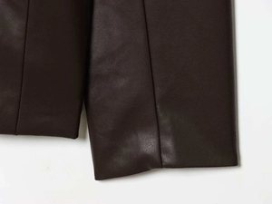 Détail de la veste en cuir PU marron foncé montrant la texture grainée et les coutures fines