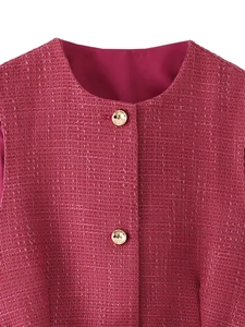 Dettaglio del gilet in tweed fucsia con tessuto strutturato e bottoni dorati goffrati
