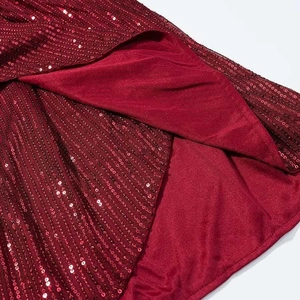Detailed macro view of sparkling burgundy sequins on deep V-neck evening dress fabric