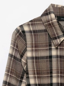 Detail of the collar and shoulder seams of this classic brown plaid long sleeve shirt