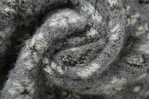 Close-up of grey and white jacquard knit sweater showing soft mohair wool texture
