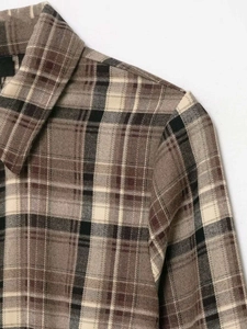 Detail view showing textured plaid flannel fabric and classic collar stitching for a women's shirt