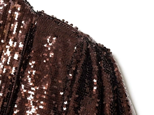 Detail of caramel sequin short dress featuring pleated puffy shoulder and metallic shine