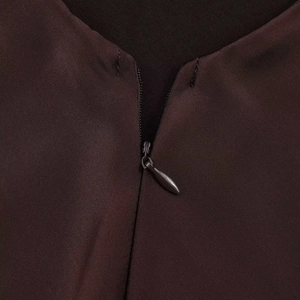 Detail shot of invisible back zipper on a brown satin texture midi dress