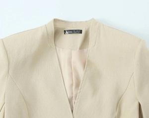 Detailansicht des hellbeigen Blazer-Ausschnitts mit Textur und Aveloria-Markenetikett
