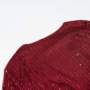 Detailed close-up of sequined burgundy fabric with elegant vertical striped texture