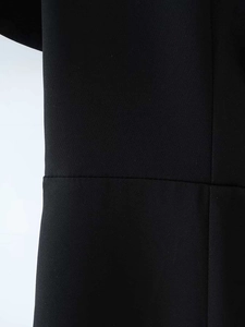 Gros plan sur la texture du tissu noir et les coutures de qualité d'une robe courte