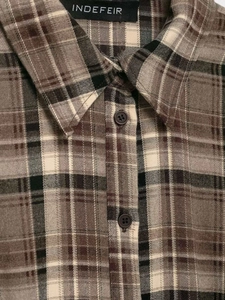 Detail of vintage plaid flannel shirt showing pointed collar and resin buttons
