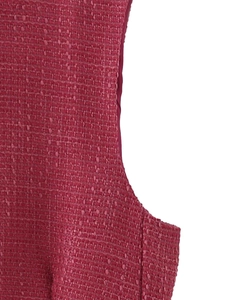 Dettaglio della trama del tessuto in tweed rosa con intreccio complesso su gilet da donna