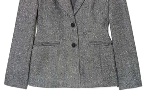 Detailed view of grey herringbone wool blazer showing dual black buttons and flap pockets