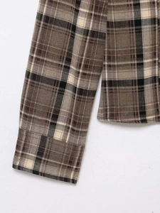 Detail of the high-quality brown plaid flannel fabric with neat stitching on sleeve cuffs