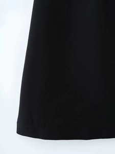 Gros plan sur l'ourlet piqué d'une mini robe noire montrant la texture fine du tissu chic