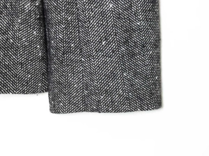 Macro shot of the premium grey herringbone wool blend fabric detail on the blazer sleeve