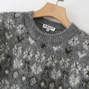 Grey and white textured mohair knit sweater with crew neck on a wooden hanger