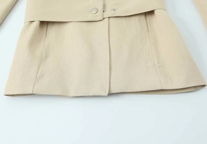 Detailansicht des beigen Blazers mit Metalldruckknöpfen und strukturierter Leinentextur