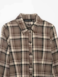 Close-up of the classic brown plaid collar and branded buttons on the slim long sleeve shirt