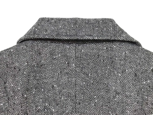 Detail shot of the grey herringbone weave fabric on a tailored wool blazer collar