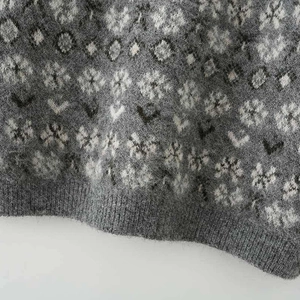 Close-up of Nordic snowflake pattern on a fluffy jacquard knit sweater with ribbed cuffs