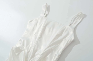 Détail d'une robe en satin blanc avec fines bretelles et coutures structurées style corset