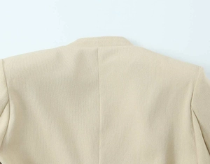 Detailaufnahme des hellbeigen Blazers mit Kragennähten und hochwertiger Webstruktur