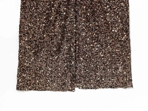 Detailed macro view of bronze sequins on a deep V-neck dress with black lining