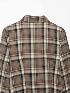 Detail of the vintage plaid shirt collar and thick flannel fabric texture in brown tones