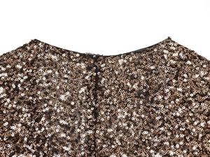 Close-up of high-density champagne gold and bronze sequins on a deep V party dress