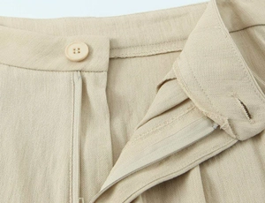 Detail der hellbeige Hose mit Knopf, Reißverschluss und gewebter Stofftextur für Damen