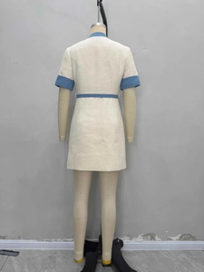 Robe élégante en tweed blanc cassé avec bordures bleues et boutons dorés vue de l'arrière