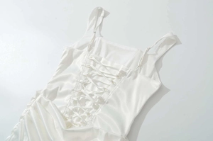 Détails du dos de la robe en satin blanc avec laçage élégant et fines bretelles réglables