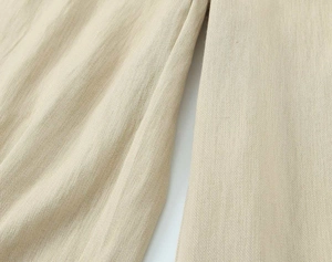 Detailaufnahme der hellbeige Leinenstoffstruktur und Webart für Damenanzugset