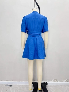 Blue V-neck A-line dress with belted waist and zipper back on minimalist model