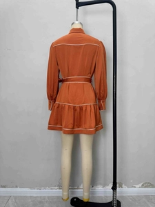 Robe orange élégante à manches longues avec passepoil blanc et ceinture à la taille