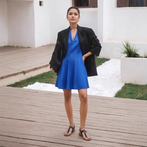 Detail of blue V-neck A-line dress paired with a black mid-length casual blazer jacket