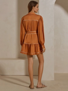 Robe courte en satin orange brûlé avec passepoil blanc contrasté et taille ceinturée