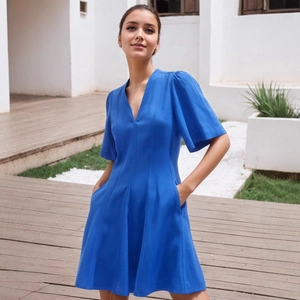 Detail of the blue V-neck dress featuring functional side pockets and an A-line silhouette