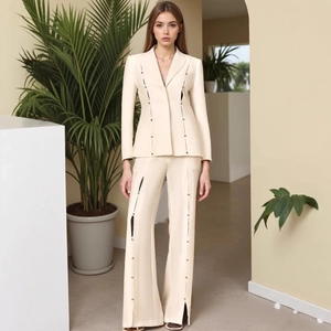 Detail view of the vertical cutout tailoring and decorative buttons on a cream slim suit