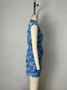 Mono azul sin mangas con bordado floral blanco y cinturón ajustable en un maniquí